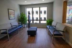 One of the common areas for seniors with a couch and window overlooking the street.